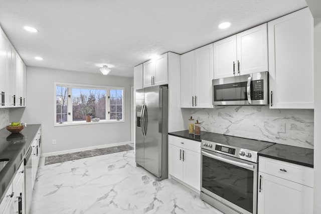 kitchen featuring stainless steel appliances, a textured ceiling, decorative backsplash, and white cabinets