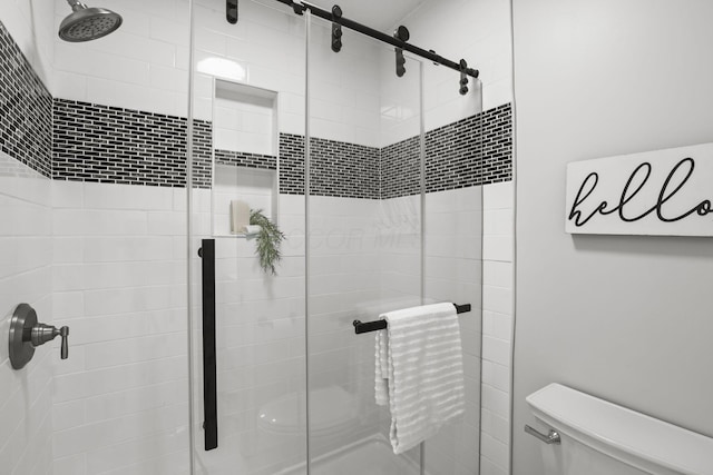 bathroom with a shower with door and toilet