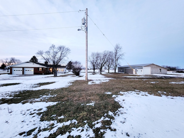 yard covered in snow featuring a garage