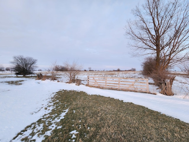 snowy yard with a rural view