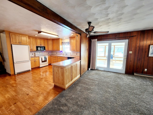 kitchen featuring sink, wooden walls, black appliances, light carpet, and kitchen peninsula