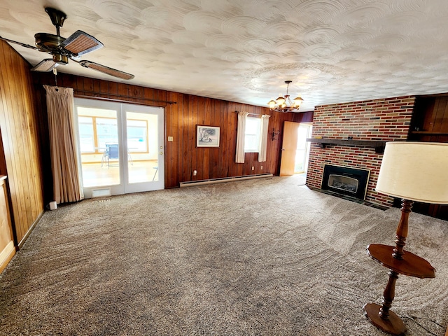 unfurnished living room featuring a healthy amount of sunlight, carpet, and a baseboard heating unit