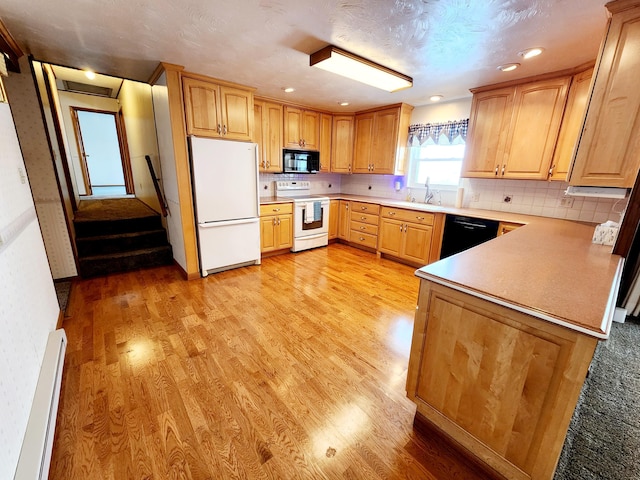 kitchen featuring a baseboard radiator, sink, decorative backsplash, black appliances, and light hardwood / wood-style flooring