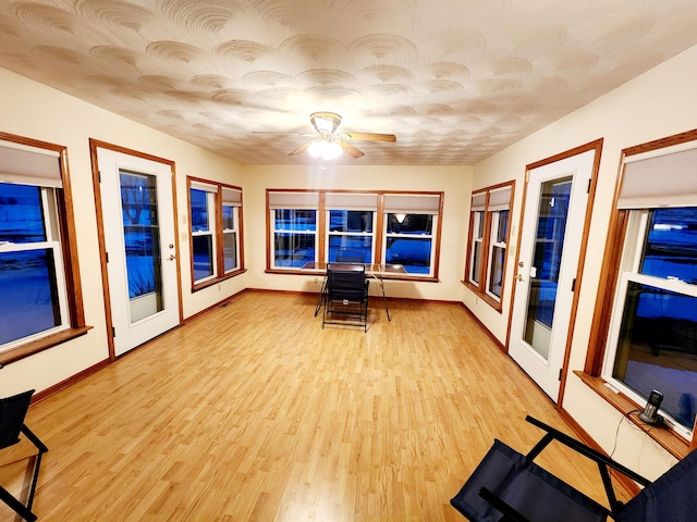 unfurnished sunroom with ceiling fan