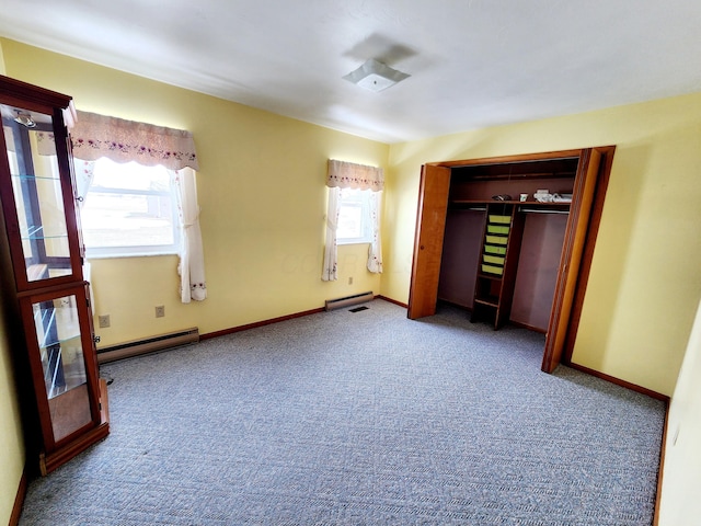 unfurnished bedroom with baseboard heating, a closet, carpet flooring, and multiple windows