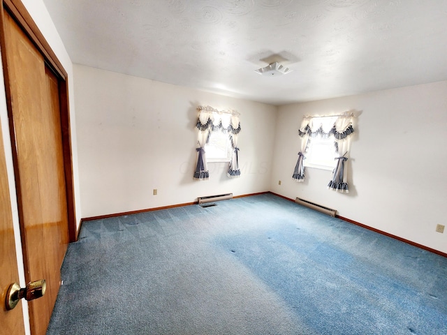 empty room featuring baseboard heating and carpet floors