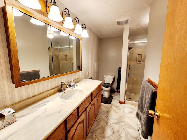 bathroom with vanity, toilet, a textured ceiling, and walk in shower