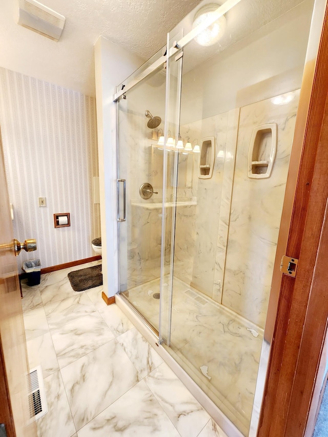 bathroom featuring a shower with door and a textured ceiling