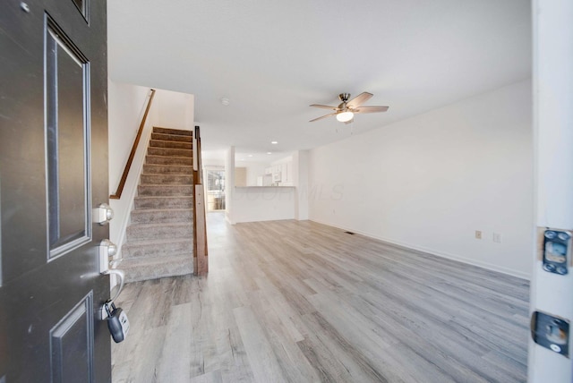 unfurnished living room with ceiling fan and light wood-type flooring