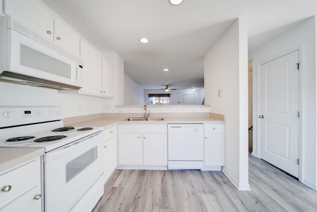 kitchen with white appliances, sink, and white cabinets