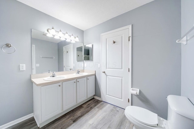 bathroom featuring vanity, hardwood / wood-style floors, a textured ceiling, and toilet