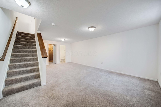 basement with a textured ceiling and carpet flooring