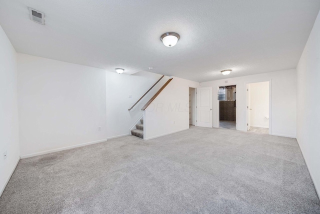 basement with light carpet and a textured ceiling