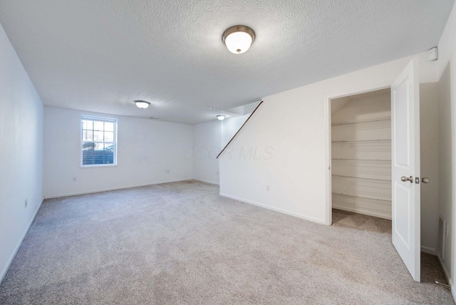 interior space featuring light carpet and a textured ceiling