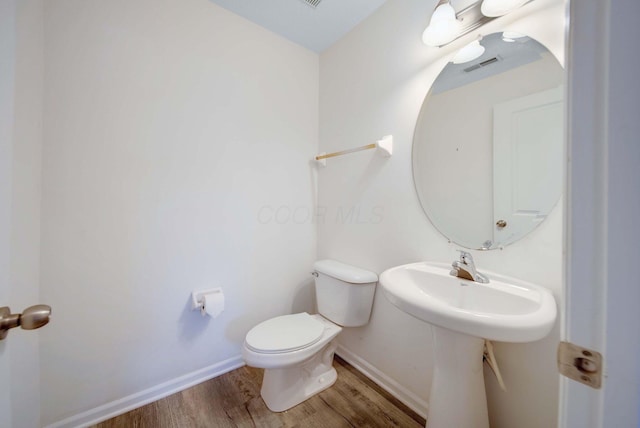 bathroom featuring wood-type flooring and toilet