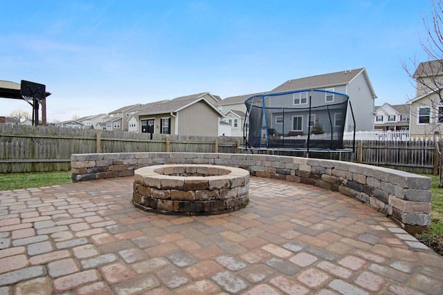 view of patio featuring a trampoline and a fire pit