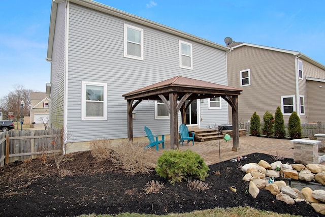 back of property with a gazebo and a patio