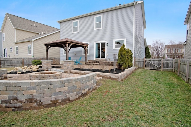 back of house with a gazebo, a lawn, and an outdoor fire pit