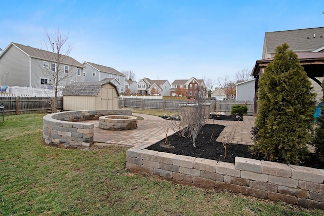 view of yard featuring a storage shed, an outdoor fire pit, and a patio