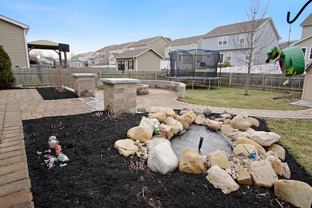 view of yard with a trampoline, a fire pit, and a patio