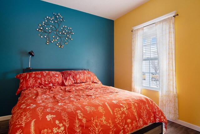 bedroom with dark hardwood / wood-style flooring