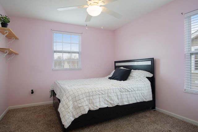 carpeted bedroom featuring multiple windows and ceiling fan