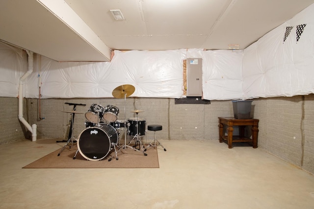 basement featuring brick wall and electric panel