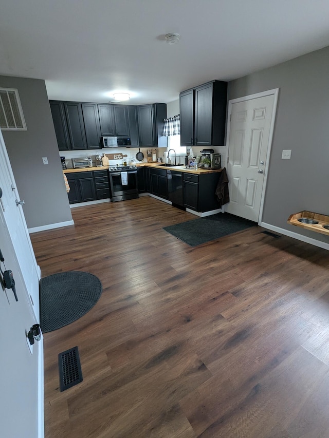 kitchen with sink, stainless steel appliances, and dark hardwood / wood-style flooring