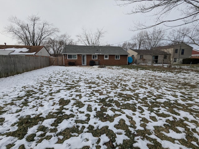 view of snow covered back of property