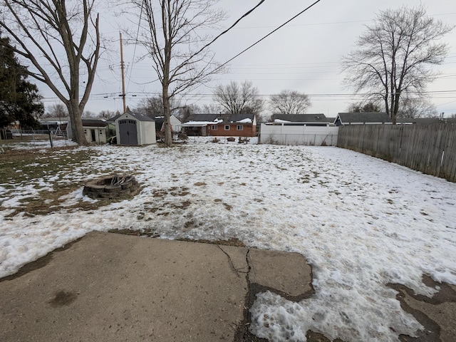 snowy yard with a shed