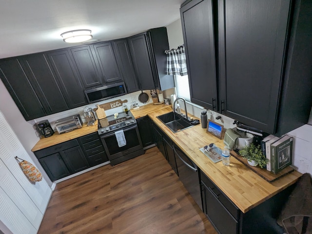 kitchen with sink, stainless steel appliances, dark hardwood / wood-style floors, and butcher block countertops