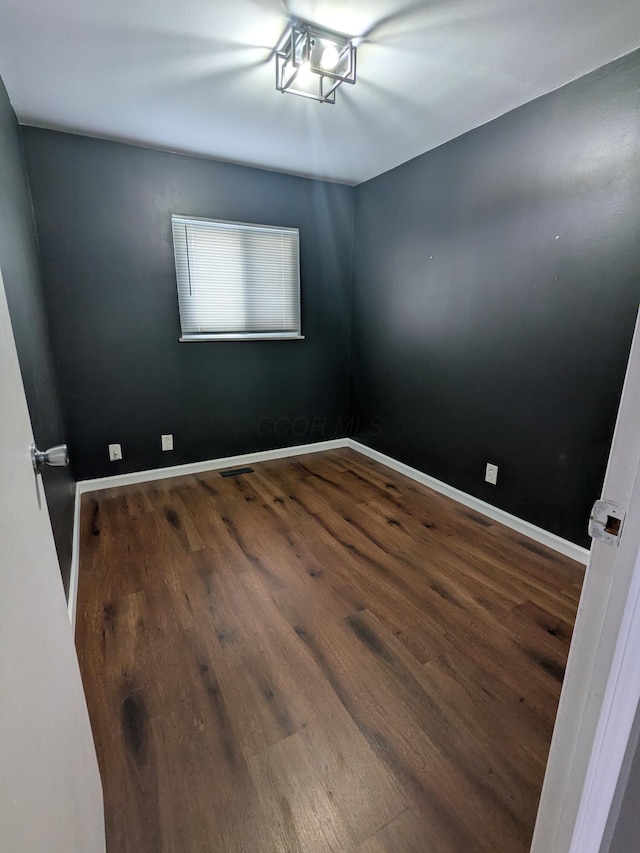 unfurnished room with dark hardwood / wood-style floors