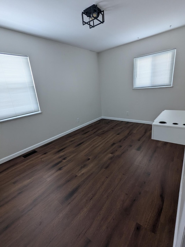 spare room with dark hardwood / wood-style floors