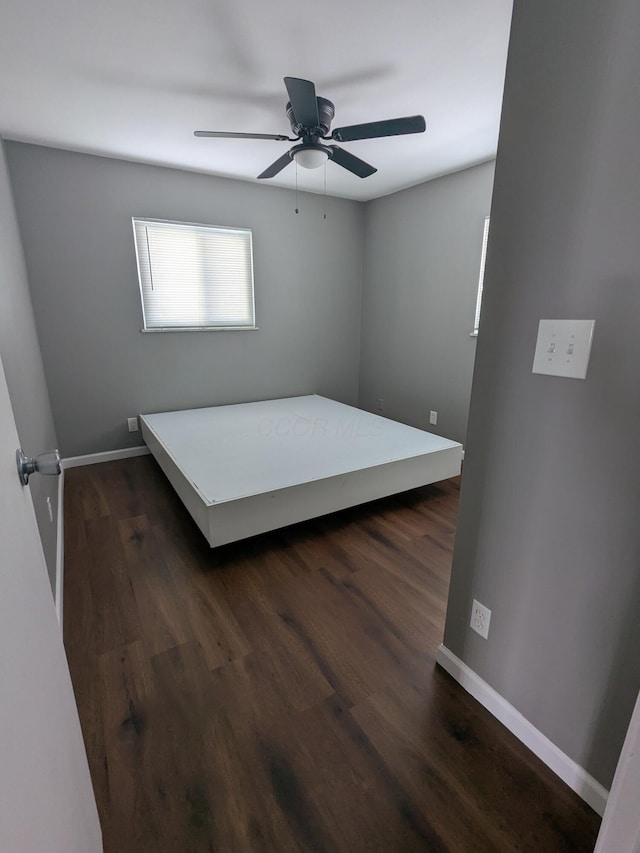 unfurnished bedroom with dark hardwood / wood-style floors and ceiling fan