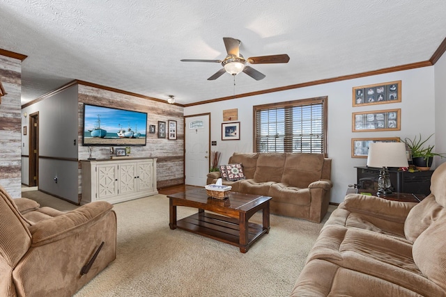 living room featuring ceiling fan, ornamental molding, light colored carpet, and a textured ceiling