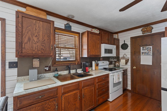 kitchen with dark hardwood / wood-style flooring, sink, white appliances, and a textured ceiling