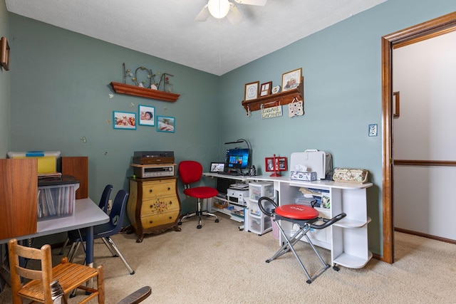 carpeted office space featuring ceiling fan and a textured ceiling