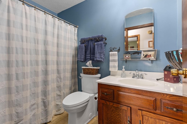 bathroom with vanity, toilet, and a textured ceiling