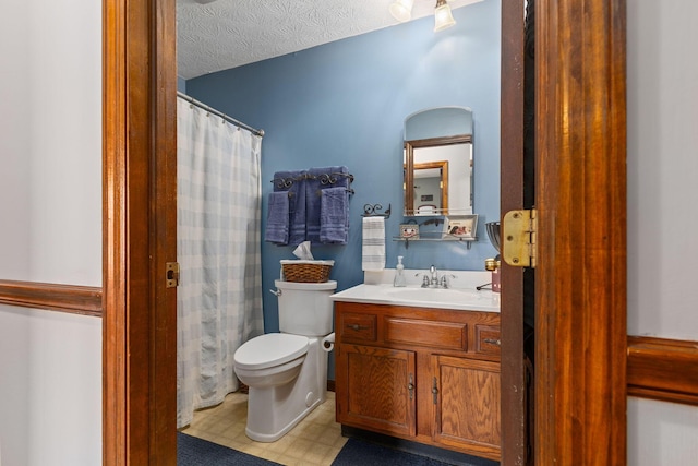 bathroom with vanity, a textured ceiling, and toilet