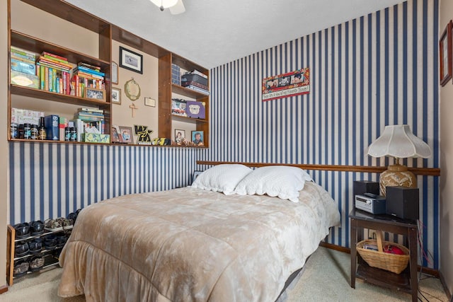 bedroom featuring light carpet, a textured ceiling, and ceiling fan