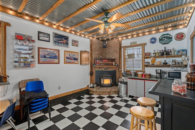 interior space featuring a wood stove and ceiling fan