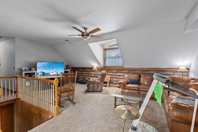 interior space featuring ceiling fan, carpet flooring, vaulted ceiling, and a textured ceiling