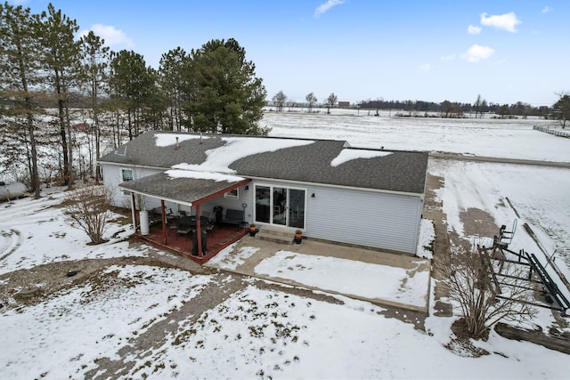 view of snow covered rear of property