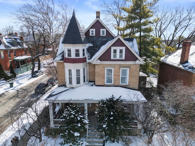 snow covered house featuring a chimney