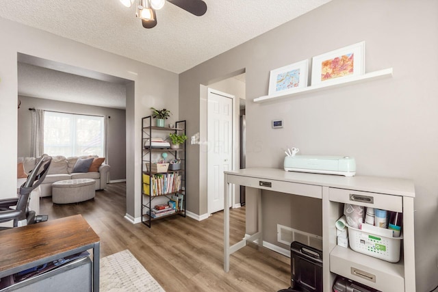 office area featuring hardwood / wood-style flooring, ceiling fan, and a textured ceiling