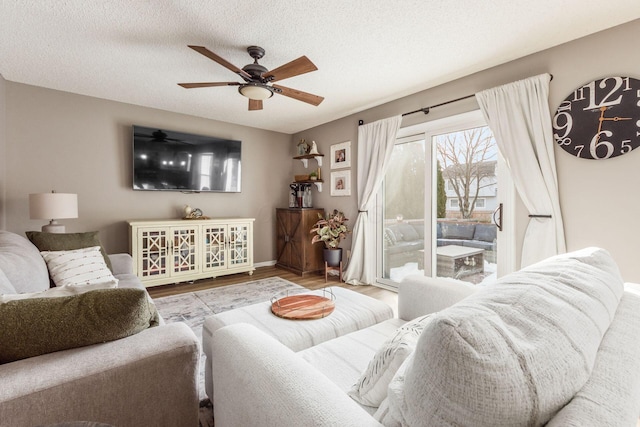 living room with ceiling fan, wood-type flooring, and a textured ceiling