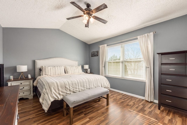 bedroom with lofted ceiling, a textured ceiling, dark wood-type flooring, and ceiling fan