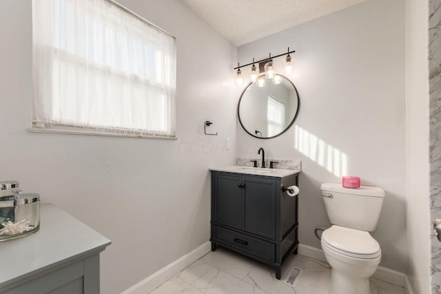 bathroom featuring vanity, toilet, and a textured ceiling