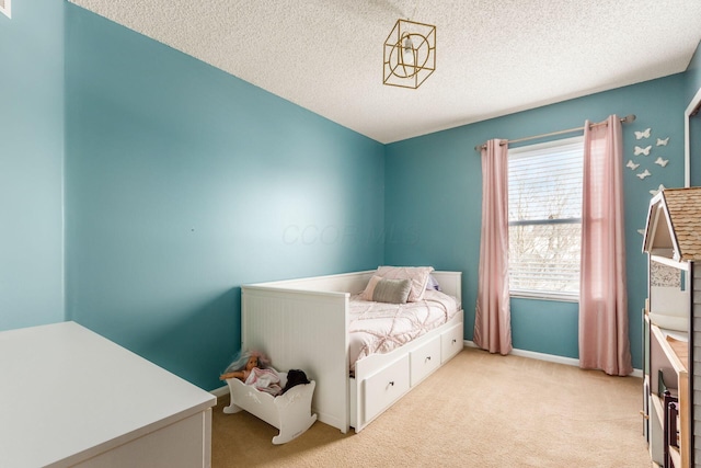 bedroom featuring light colored carpet and a textured ceiling