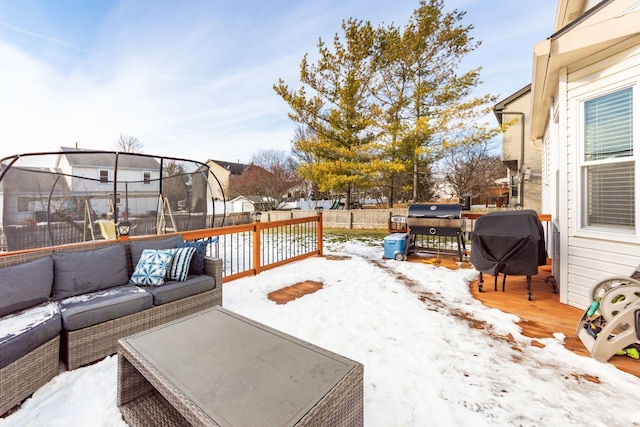 snow covered deck with a trampoline, outdoor lounge area, and area for grilling